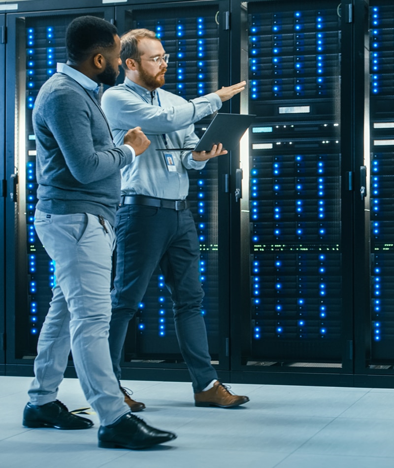 IT specialists walking along a row of servers, representing managed services in Modesto CA.