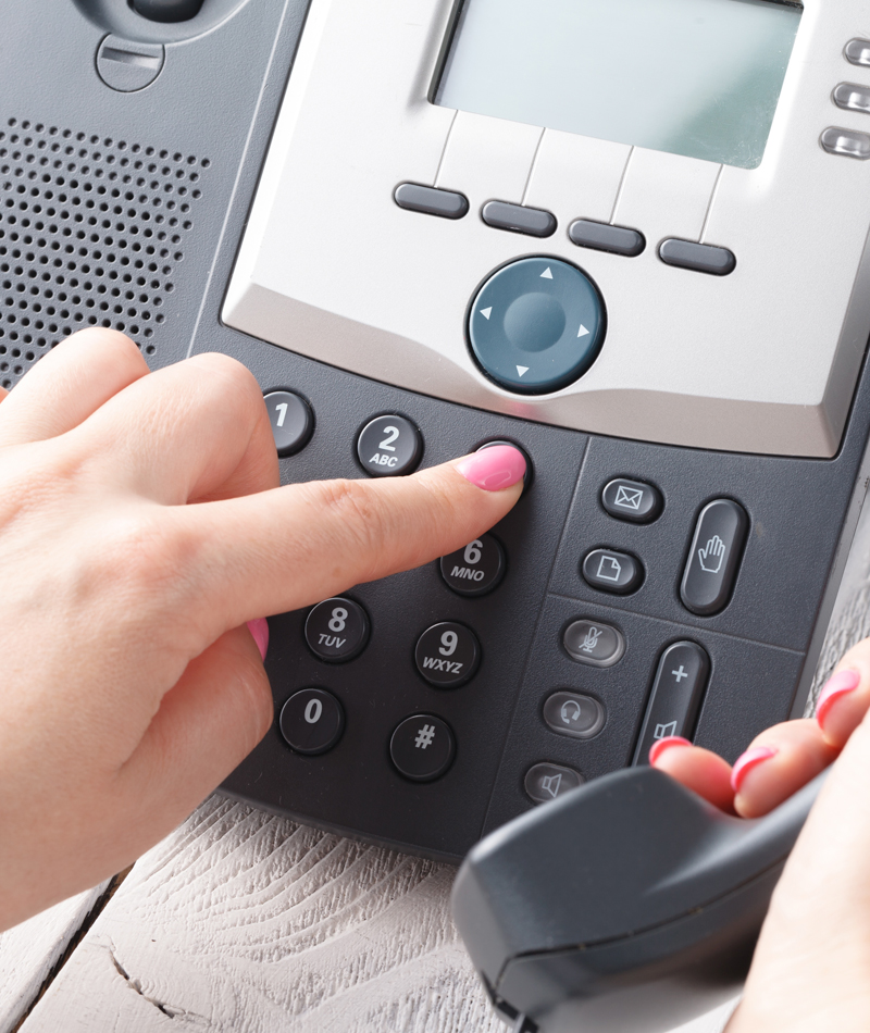A finger pressing a button on a phone, representing Modesto VoIP services for businesses.