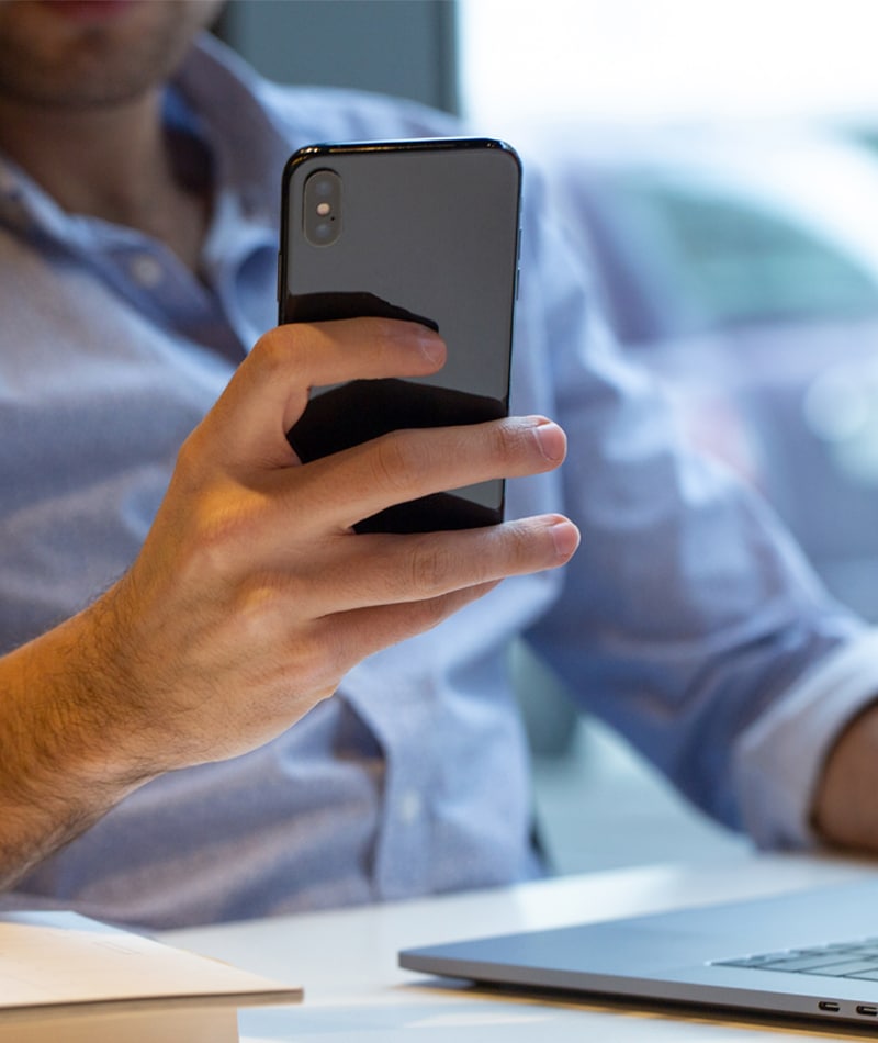 A businessman holding a cellphone, representing VoIP in San Antonio TX.