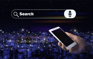 A hand holding a smartphone with a search bar in the background of the image.