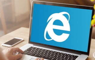 A laptop showing a large Internet Explorer logo.