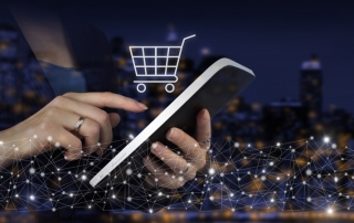 Hands using a tablet with a virtual shopping cart above the screen.