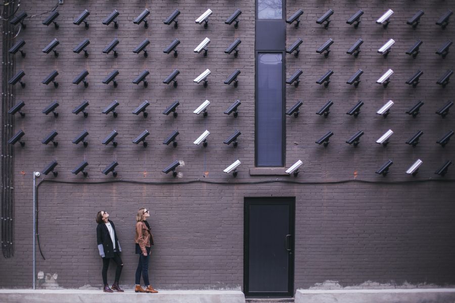 endpoint protection concept - two women outside a building looking up at a bunch of surveillance cameras