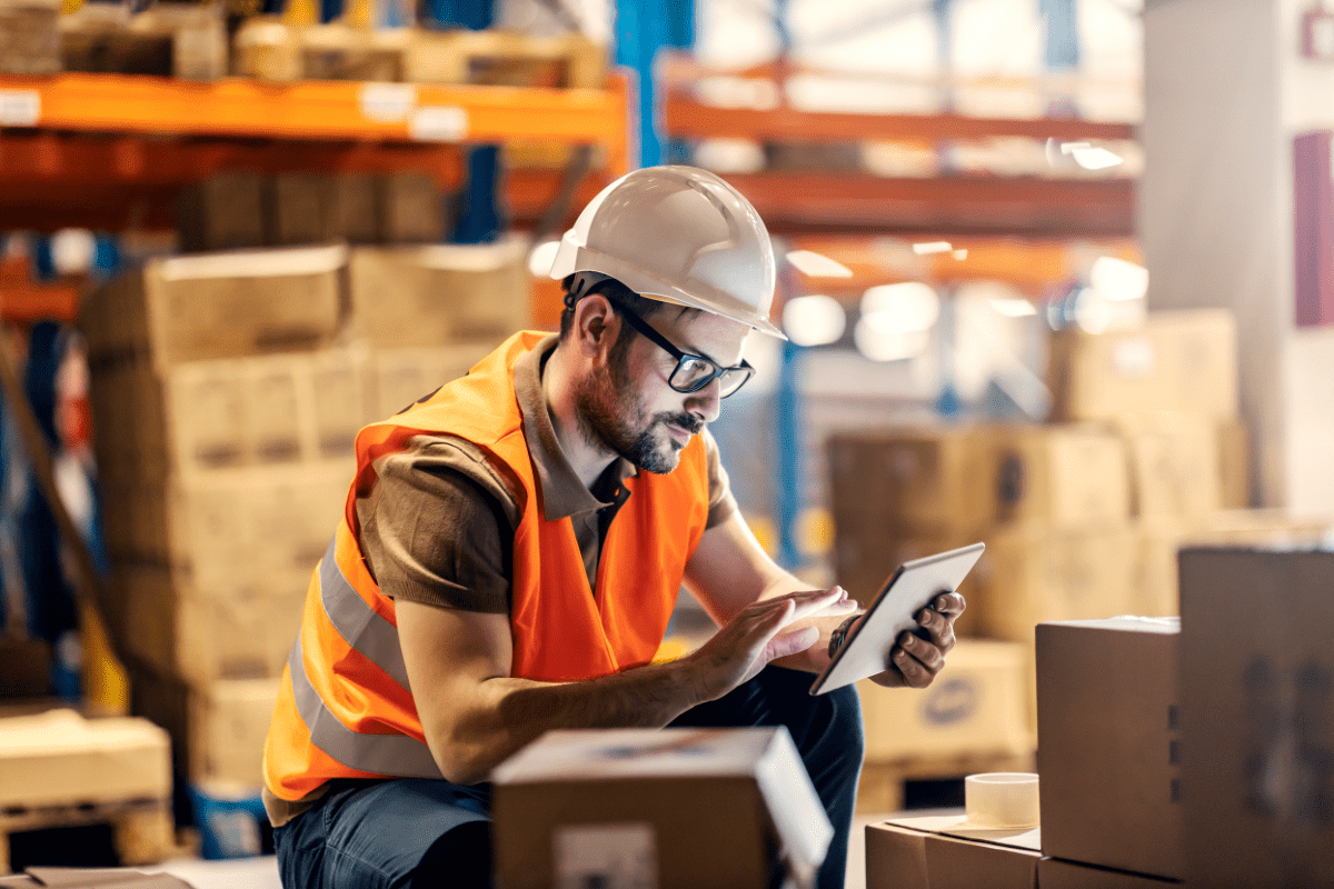 An employee checking their warehouse cybersecurity settings from their tablet.
