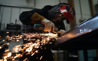 a man working with an angle grinder in a manufacturing firm